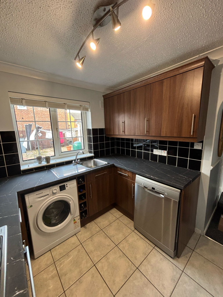 Brown kitchen cupboards and dark worktops before wrapping