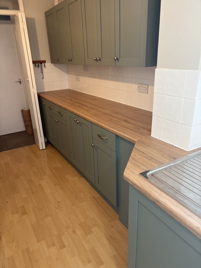 Green kitchen cupboards and wood effect wrapped worktop in Bowthorpe