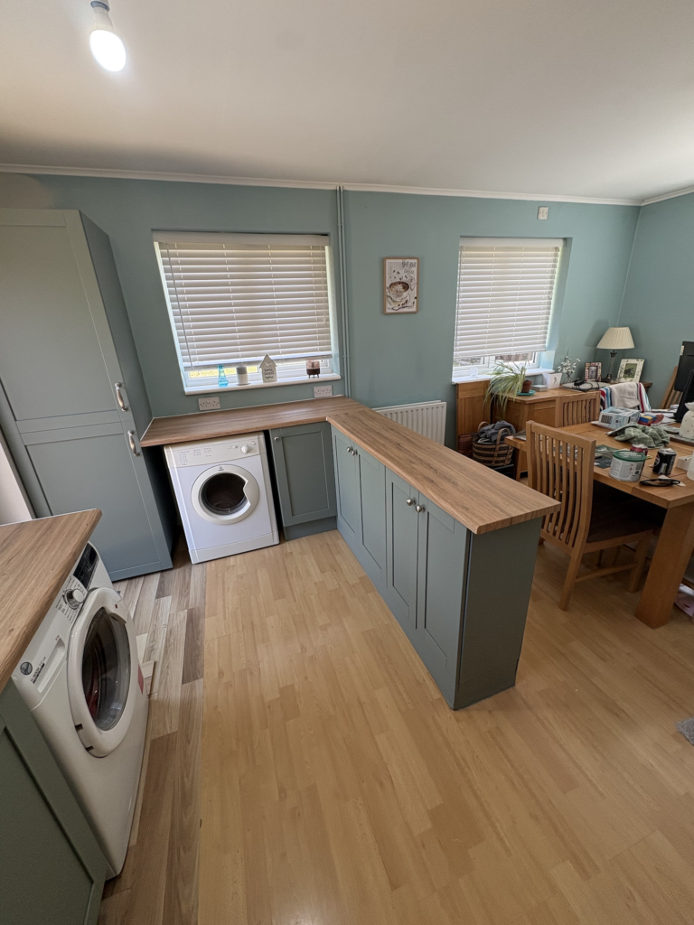 Green kitchen island with a wood effect wrapped worktop in Bowthorpe