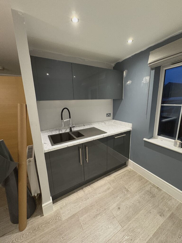 Dark grey wrapped kitchen cupboards with a pale worktop
