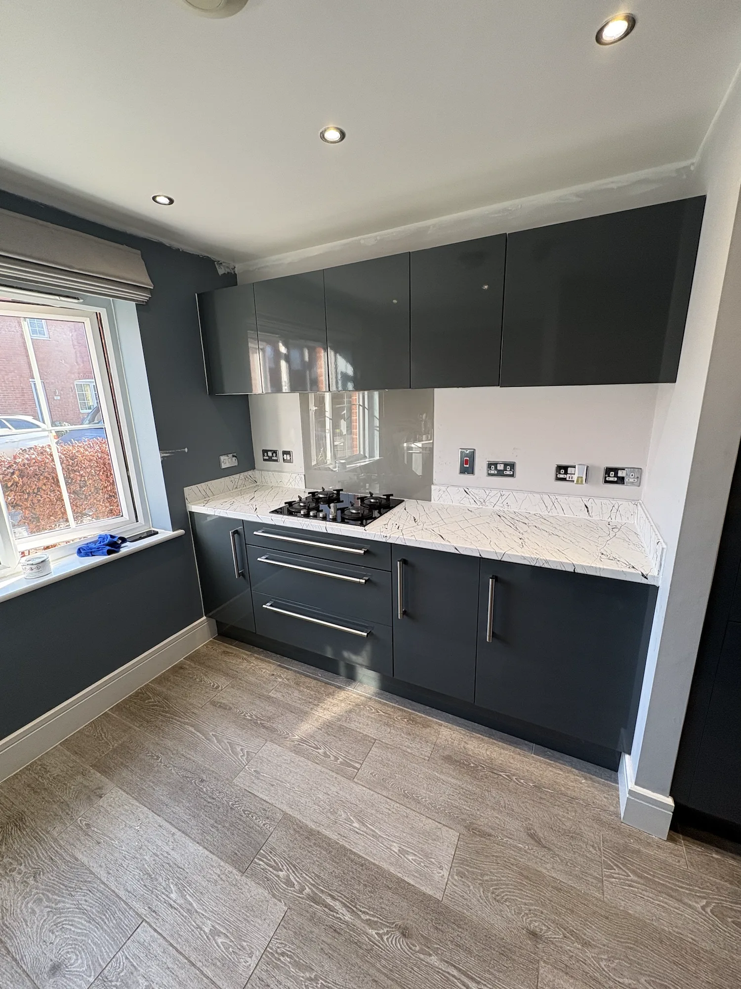 Completed gloss grey kitchen wrap in Swaffham with white marble-effect worktops