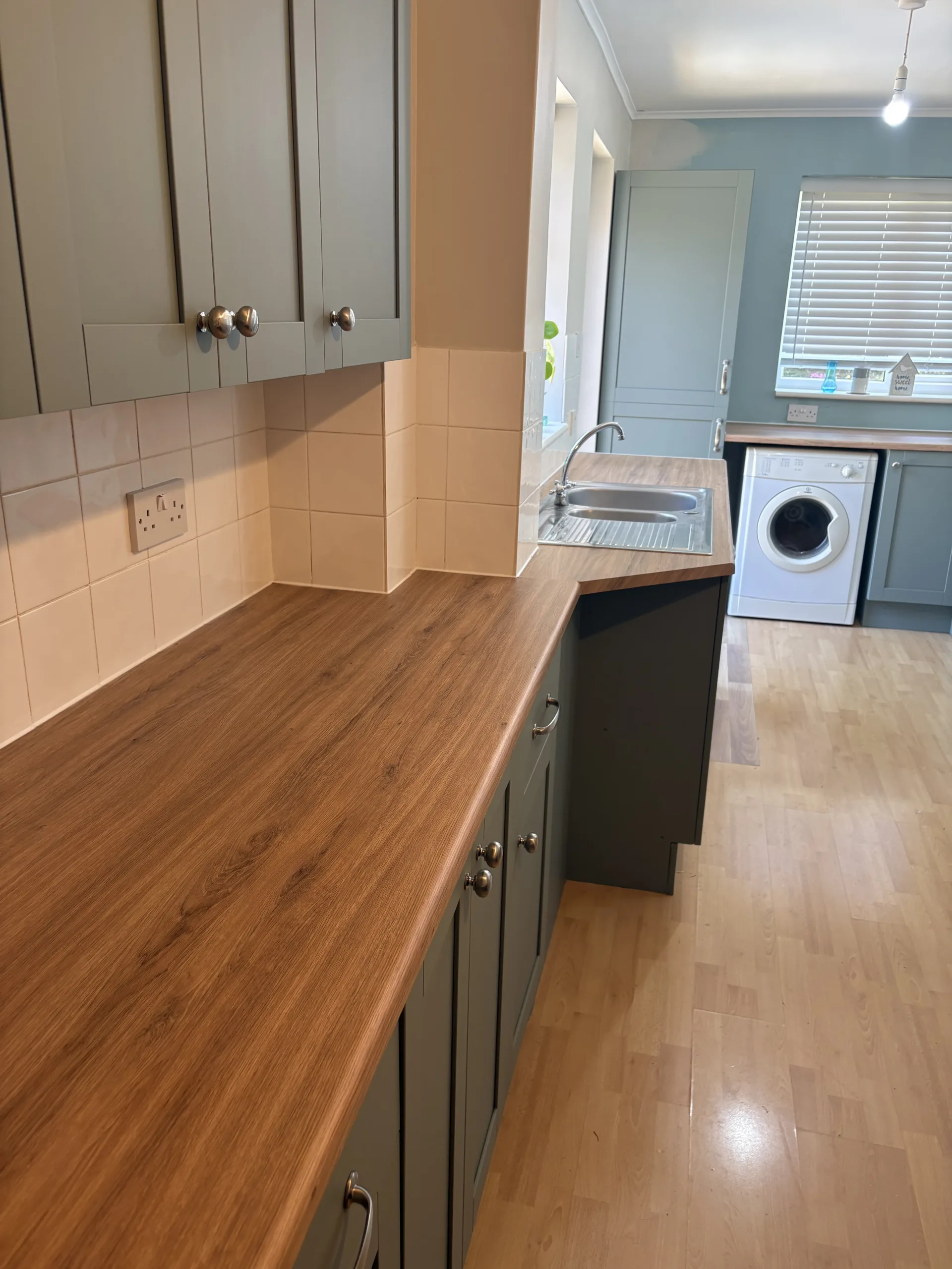 Finished warm oak-effect worktop wrapping around kitchen sink in Bowthorpe, Norwich