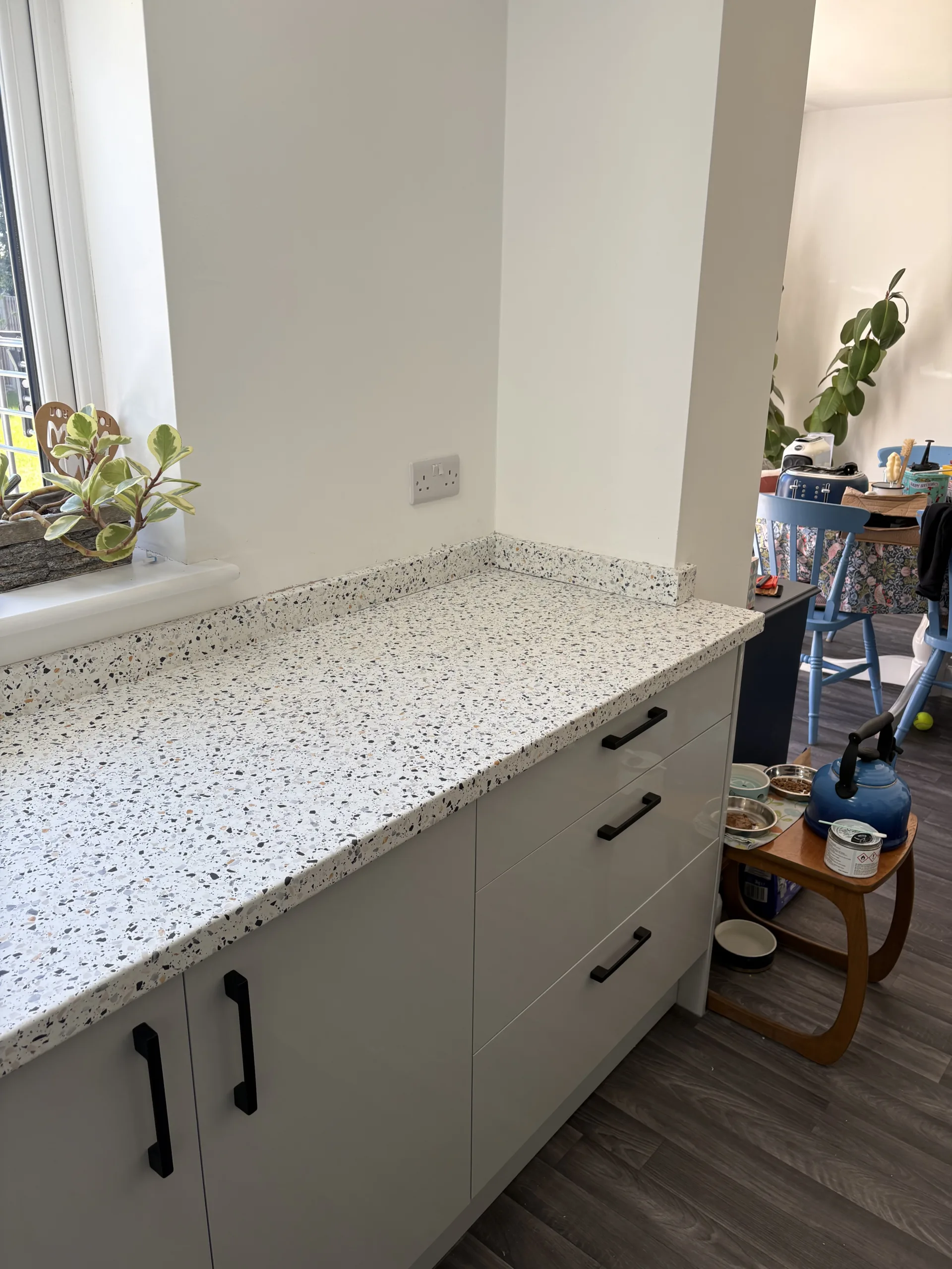 Finished light terrazzo-effect wrapped worktop around induction hob in Bawburgh, near Norwich